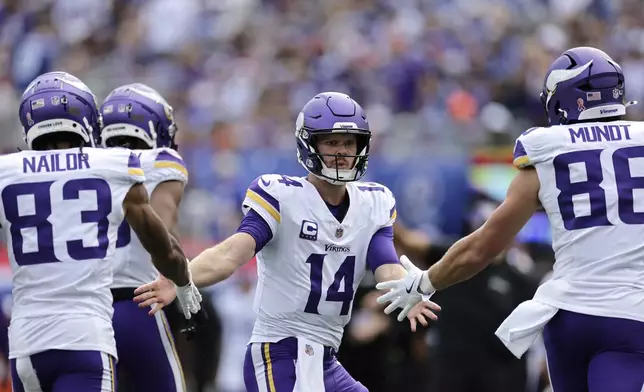 Minnesota Vikings quarterback Sam Darnold (14) celebrates after a 21-yard touchdown catch by teammate wide receiver Jalen Nailor (83) during the second half of an NFL football game against the New York Giants, Sunday, Sept. 8, 2024, in East Rutherford, N.J. (AP Photo/Adam Hunger)