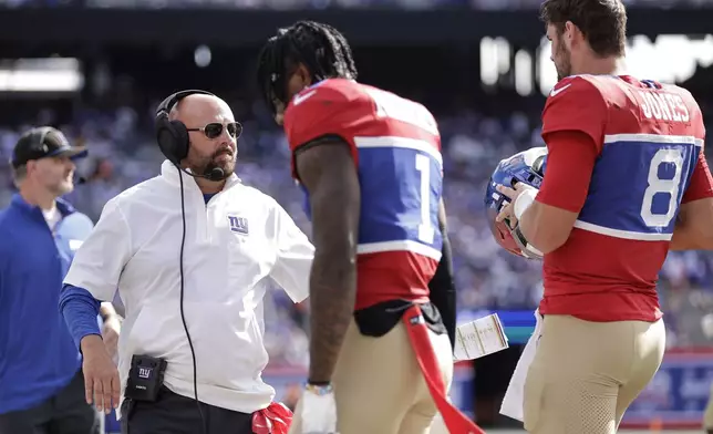 New York Giants head coach Brian Daboll stands on the sideline as wide receiver Malik Nabers (1) and quarterback Daniel Jones (8) walk off the field during the second half of an NFL football game against the Minnesota Vikings, Sunday, Sept. 8, 2024, in East Rutherford, N.J. (AP Photo/Adam Hunger)