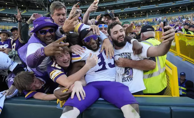 Minnesota Vikings running back Aaron Jones (33) celebrates the team's win after an NFL football game against the Green Bay Packers, Sunday, Sept. 29, 2024, in Green Bay, Wis. (AP Photo/Morry Gash)