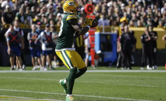 Green Bay Packers wide receiver Dontayvion Wicks (13) catches a touchdown pass in the end zone for a touchdown during the second half of an NFL football game against the Minnesota Vikings, Sunday, Sept. 29, 2024, in Green Bay, Wis. (AP Photo/Matt Ludtke)