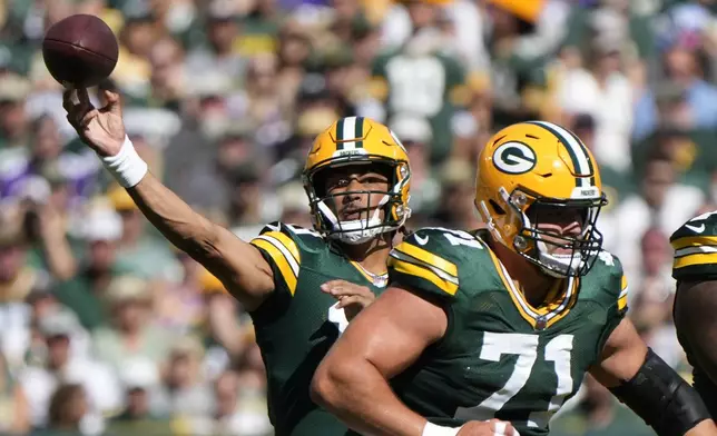 Green Bay Packers quarterback Jordan Love, left, throws a pass during the first half of an NFL football game against the Minnesota Vikings, Sunday, Sept. 29, 2024, in Green Bay, Wis. (AP Photo/Morry Gash)