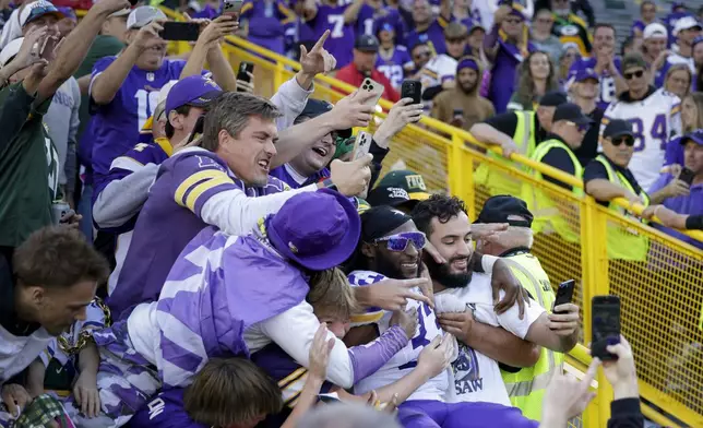 Minnesota Vikings running back Aaron Jones (33) celebrates with fans after the team's win against the Green Bay Packers in an NFL football game Sunday, Sept. 29, 2024, in Green Bay, Wis. (AP Photo/Matt Ludtke)