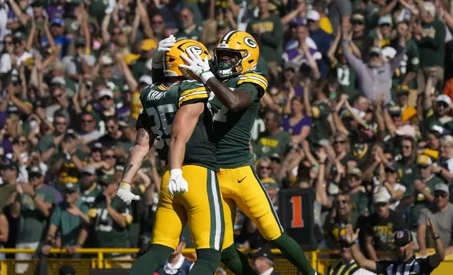 Green Bay Packers tight end Tucker Kraft, left, and wide receiver Romeo Doubs, right, celebrate a touchdown during the second half of an NFL football game against the Minnesota Vikings, Sunday, Sept. 29, 2024, in Green Bay, Wis. (AP Photo/Morry Gash)