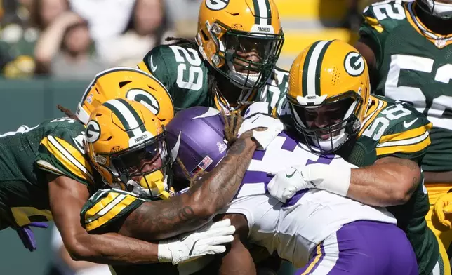 Green Bay Packers defenders tackle Minnesota Vikings running back Aaron Jones, center, during the first half of an NFL football game Sunday, Sept. 29, 2024, in Green Bay, Wis. (AP Photo/Morry Gash)