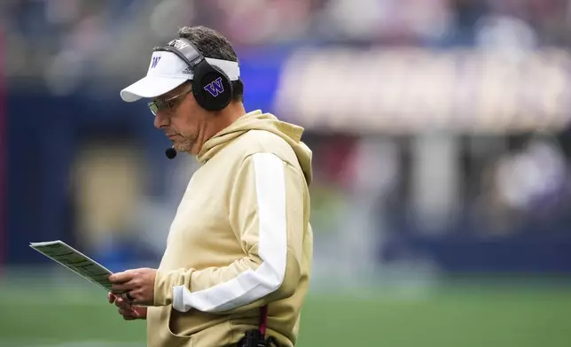 Washington head coach Jedd Fisch looks down at a play sheet during the first half of an NCAA college football game against Washington State, Saturday, Sept. 14, 2024, in Seattle. (AP Photo/Lindsey Wasson)