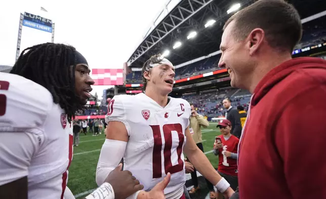 Washington State quarterback John Mateer (10) greets head coach Jake Dickert, right, as they celebrate a 24-19 win over Washington in an NCAA college football game Saturday, Sept. 14, 2024, in Seattle. (AP Photo/Lindsey Wasson)