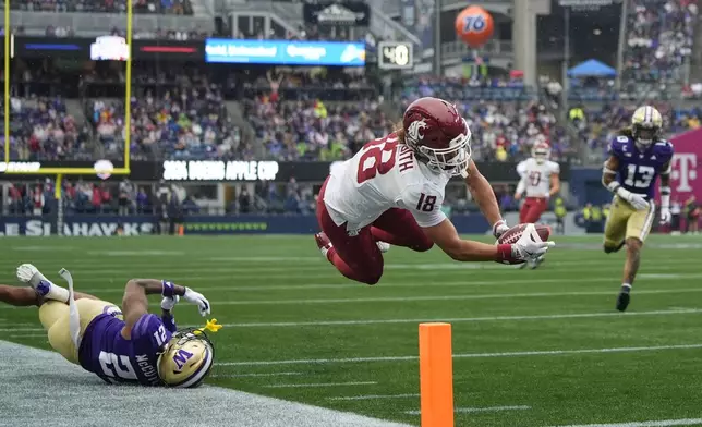 Washington State wide receiver Josh Meredith (18) leaps for a touchdown against Washington defensive back Dyson McCutcheon (21) during the second half of an NCAA college football game Saturday, Sept. 14, 2024, in Seattle. Washington State won 24-19. (AP Photo/Lindsey Wasson)