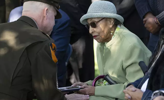 FILE - First Army's Command Sgt. Maj. Chris Prosser, left, presents Joann Woodson with her husband's Combat Medic Badge during a posthumous medal ceremony at Arlington National Cemetery Oct. 11, 2023 in Arlington, Va. (AP Photo/Kevin Wolf, File)