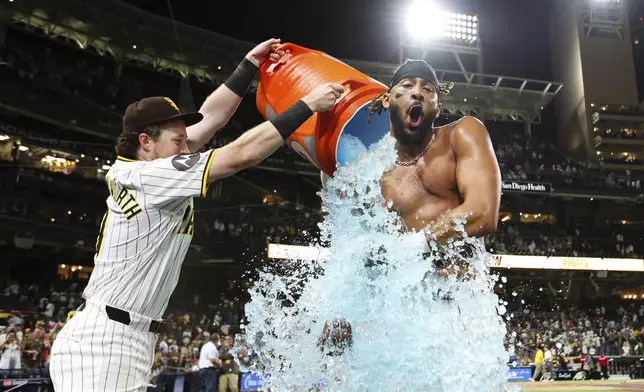 San Diego Padres' Fernando Tatis Jr., right, reacts after having a cooler dumped on him by Jake Cronenworth following a walk-off hit against the Detroit Tigers in the tenth inning of a baseball game Wednesday, Sept. 4, 2024, in San Diego. (AP Photo/Derrick Tuskan)