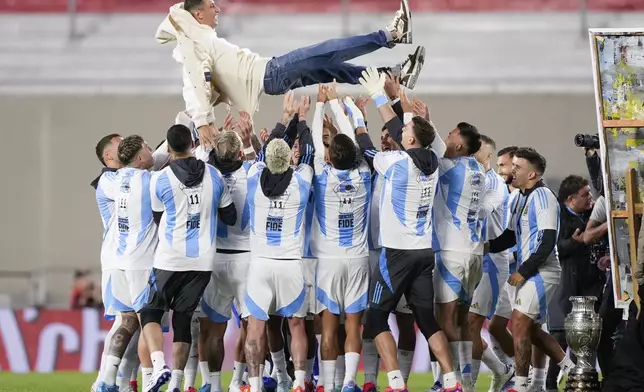 Players of Argentina hoist Ángel Di María before a qualifying soccer match for the FIFA World Cup 2026 against Chile in Buenos Aires, Argentina, Thursday, Sept. 5, 2024. (AP Photo/Natacha Pisarenko)