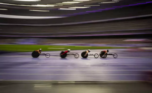 Paralympic athletes compete at Women's 5000m - T54 round 1, at the Stade de France stadium, during the 2024 Paralympics, Friday, Aug. 30, 2024, in Paris, France. (AP Photo/Emilio Morenatti)