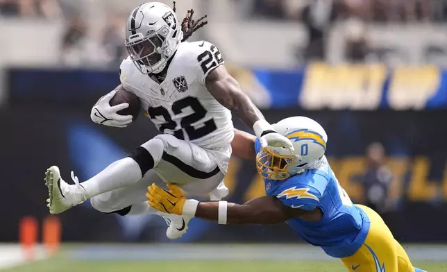 Las Vegas Raiders running back Alexander Mattison (22) runs for a touchdown against Los Angeles Chargers linebacker Daiyan Henley, right, during the first half of an NFL football game, Sunday, Sept. 8, 2024, in Inglewood, Calif. (AP Photo/Marcio Jose Sanchez)