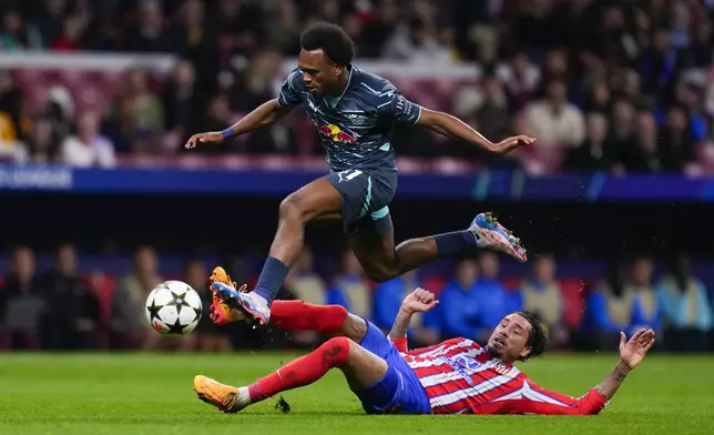 Leipzig's Lois Openda, top, is challenged by Atletico Madrid's Jose Gimenez during to the Champions League opening phase soccer match between Atletico Madrid and RB Leipzig at the Metropolitano stadium, in Madrid, Thursday, Sept. 19, 2024. (AP Photo/Manu Fernandez)