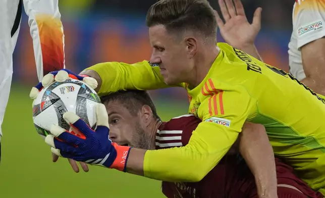 Germany's goalkeeper Marc-Andre Ter Stegen, centre, makes a save over Hungary's Barnabas Varga during the UEFA Nations League soccer match between Germany and Hungary at the Merkur Spiel-Arena in Dusseldorf, Germany, Saturday, Sept. 7, 2024. (AP Photo/Michael Probst)