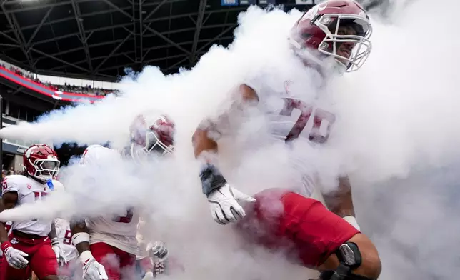 Washington State players run out onto the field before an NCAA college football game against Washington, Saturday, Sept. 14, 2024, in Seattle. (AP Photo/Lindsey Wasson)