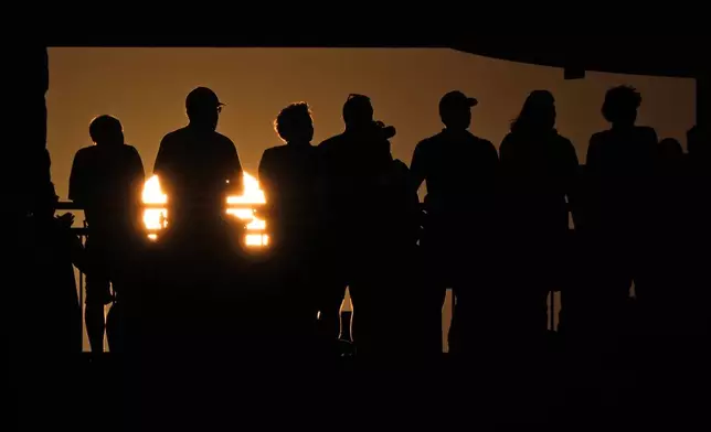 Fans watch as the sun sets during the first half of an NCAA college football game between Kansas State and Arizona Friday, Sept. 13, 2024, in Manhattan, Kan. (AP Photo/Charlie Riedel)