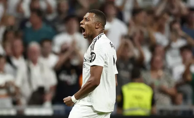 Real Madrid's Kylian Mbappe celebrates after scoring his sides second goal during the Spanish La Liga soccer match between Real Madrid and Betis at the Santiago Bernabeu stadium in Madrid, Spain, Sunday, Sept. 1, 2024. (AP Photo/Pablo Garcia)