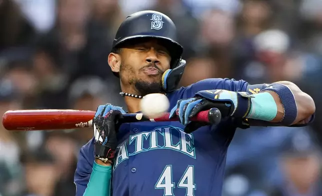 Seattle Mariners' Julio Rodríguez winces at a close ball after pulling back from a bunt attempt against the Tampa Bay Rays during the fourth inning of a baseball game, Tuesday, Aug. 27, 2024, in Seattle. (AP Photo/Lindsey Wasson)