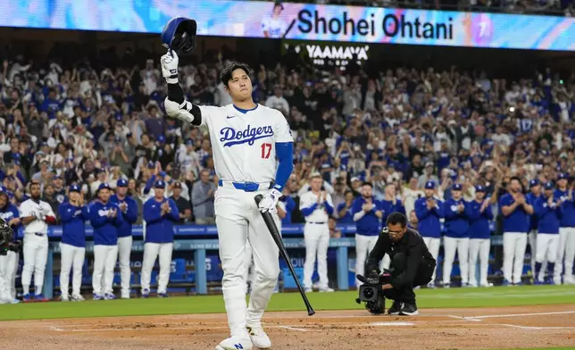 Los Angeles Dodgers designated hitter Shohei Ohtani (17) is honored during the first inning of a baseball game against the Colorado Rockies in Los Angeles, Friday, Sept. 20, 2024. Ohtani was the first MLB player to achieve 50 home runs and 50 stolen bases in a single season. (AP Photo/Ashley Landis)