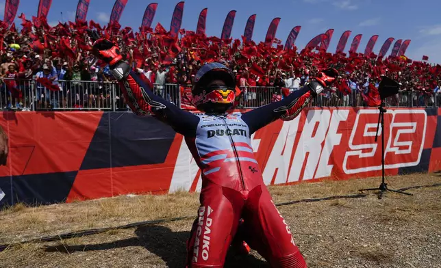 Spain's rider Marc Marquez of the Gresini Racing MotoGP celebrates in front of fans after winning the MotoGP Aragon Motorcycle Grand Prix at the MotorLand Aragon circuit, in Alcaniz, Spain, Sunday, Sept. 1, 2024. (AP Photo/Jose Breton)