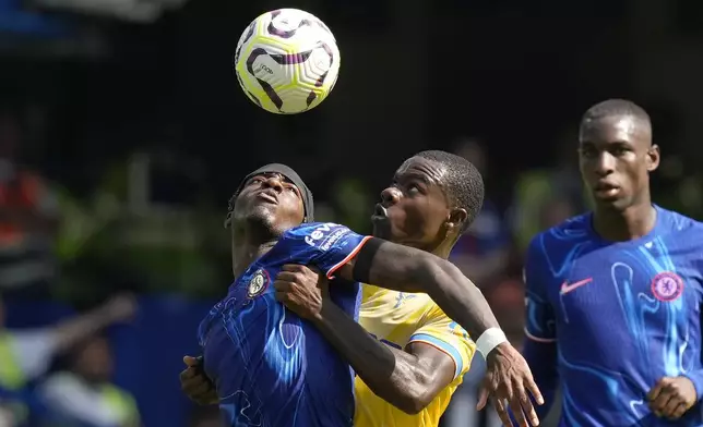 Chelsea's Noni Madueke, left, and Crystal Palace's Tyrick Mitchell, center, fight for the ball during the English Premier League soccer match between Chelsea and Crystal Palace, at the Stamford Bridge Stadium in London, Sunday, Sept. 1, 2024. (AP Photo/Frank Augstein)