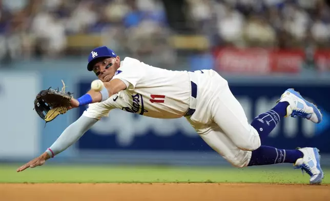 Los Angeles Dodgers shortstop Miguel Rojas can't get to a ball hit for a two RBI single by Chicago Cubs' Miguel Amaya during the sixth inning of a baseball game, Monday, Sept. 9, 2024, in Los Angeles. (AP Photo/Mark J. Terrill)