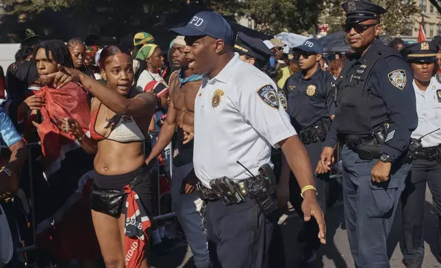 Police move revelers from the street after a shooting on Eastern Parkway, near the corner of Franklin Avenue, during the West Indian Day Parade on Monday, Sept. 2, 2024, in the Brooklyn borough of New York. (AP Photo/Andres Kudacki)