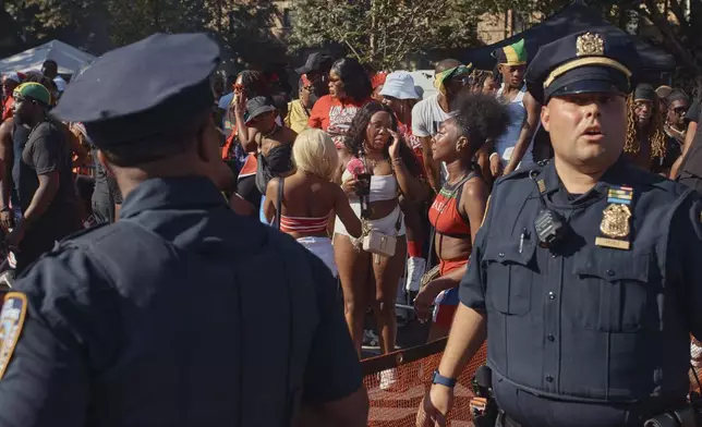 Police move revelers from the street after a shooting on Eastern Parkway, near the corner of Franklin Avenue, during the West Indian Day Parade on Monday, Sept. 2, 2024, in the Brooklyn borough of New York. (AP Photo/Andres Kudacki)