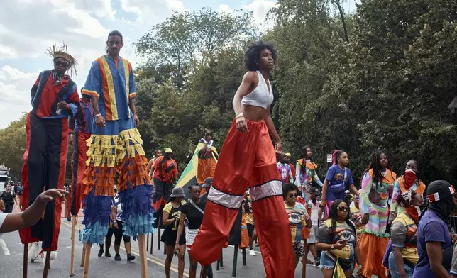 Revelers walk on stilts during the West Indian Day Parade on Monday, Sept. 2, 2024, in the Brooklyn borough of New York. (AP Photo/Andres Kudacki)