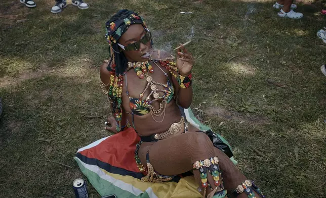 A reveler smokes during the West Indian Day Parade on Monday, Sept. 2, 2024, in the Brooklyn borough of New York. (AP Photo/Andres Kudacki)