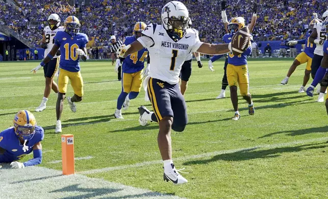 West Virginia running back Jahiem White (1) scores during the first half of an NCAA college football game against Pittsburgh, Saturday, Sept. 14, 2024, in Pittsburgh. (AP Photo/Matt Freed)