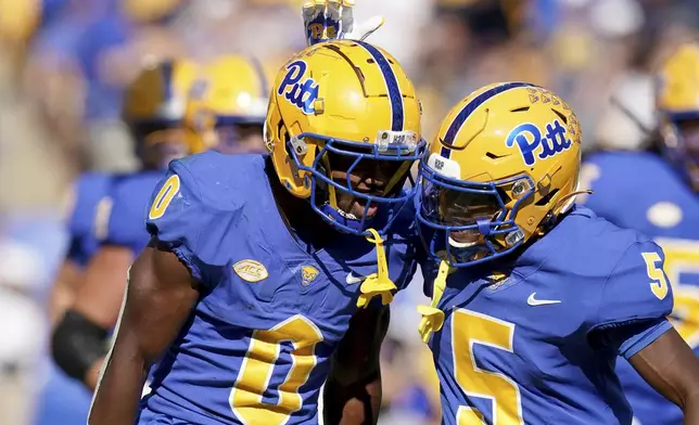 Pittsburgh running back Desmond Reid (0) celebrates with Raphael Williams Jr. (5) after scoring during the first half of an NCAA college football game against West Virginia Saturday, Sept. 14, 2024, in Pittsburgh. (AP Photo/Matt Freed)