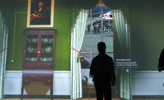 Members of the media tour an interactive 3D room of the White House Green Room as is today, shown at The People's House exhibit, Monday, Sept. 16, 2024 in Washington. (AP Photo/Jose Luis Magana)