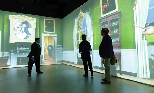 White House Historical Association President Stewart McLaurin tour members of the media in an interactive 3D room of the White House Green Room as is today, shown at The People's House exhibit, Monday, Sept. 16, 2024 in Washington. (AP Photo/Jose Luis Magana)