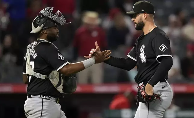 Chicago White Sox catcher Chuckie Robinson, left, and relief pitcher Justin Anderson congratulate each other after the White Sox defeated the Los Angeles Angels 8-4 in a baseball game, Monday, Sept. 16, 2024, in Anaheim, Calif. (AP Photo/Mark J. Terrill)