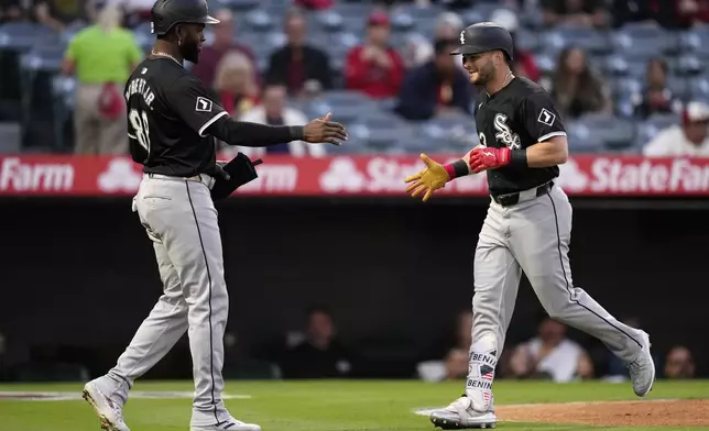 Chicago White Sox's Andrew Benintendi, right, is congratulated by Luis Robert Jr. after hitting a two-run home run during the first inning of a baseball game against the Los Angeles Angels, Monday, Sept. 16, 2024, in Anaheim, Calif. (AP Photo/Mark J. Terrill)