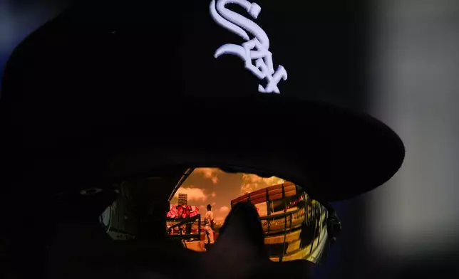 Chicago White Sox first base coach/outfield coach Jason Bourgeois (38) is reflected in the glasses of third baseman Bryan Ramos in the dugout during the sixth inning of a baseball game Los Angeles Angels in Anaheim, Calif., Wednesday, Sept. 18, 2024. (AP Photo/Ashley Landis)