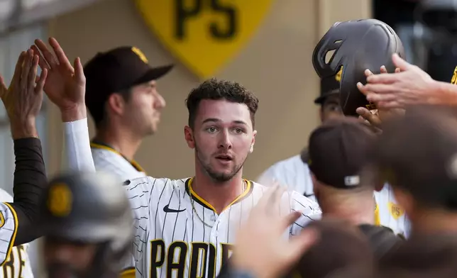 San Diego Padres' Jackson Merrill celebrates in the dugout after scoring off a two-run home run hit by Xander Bogaerts during the second inning of a baseball game against the Chicago White Sox, Saturday, Sept. 21, 2024, in San Diego. (AP Photo/Ryan Sun)