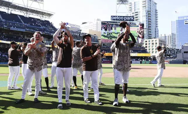 From left to right, San Diego Padres' Jackson Merrill, Tyler Wade, Adrian Morejon, and Robert Suarez acknowledge the fans after the team defeated the Chicago White Sox in a baseball game, Sunday, Sept. 22, 2024, in San Diego. (AP Photo/Derrick Tuskan)