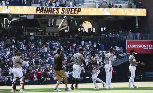 San Diego Padres' Jurickson Profar, third from right, celebrates with Robert Suarez after the team defeated the Chicago White Sox in a baseball game Sunday, Sept. 22, 2024, in San Diego. (AP Photo/Derrick Tuskan)