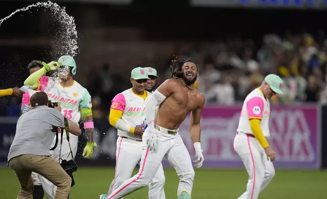 San Diego Padres' Fernando Tatis Jr. is doused after hitting a walk off double during the tenth inning of a baseball game to defeat the Chicago White Sox 3-2, Friday, Sept. 20, 2024, in San Diego. (AP Photo/Gregory Bull)