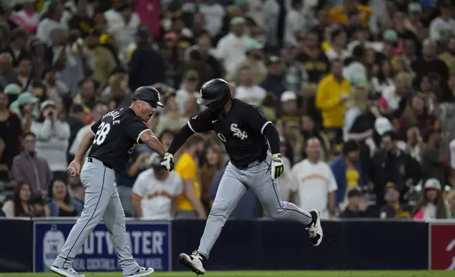 Chicago White Sox's Lenyn Sosa, right, celebrates his two-run home run with third base coach Justin Jirschele during the ninth inning of a baseball game against the San Diego Padres, Friday, Sept. 20, 2024, in San Diego. (AP Photo/Gregory Bull)