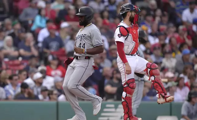 Chicago White Sox's Bryan Ramos, left, scores in front of Boston Red Sox catcher Connor Wong, right, on a double hit by Dominic Fletcher in the ninth inning of a baseball game, Sunday, Sept. 8, 2024, in Boston. (AP Photo/Steven Senne)