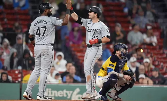 Chicago White Sox's Andrew Benintendi (23) celebrates his three-run home run that also drove in Chuckie Robinson (47) behind Boston Red Sox catcher Danny Jansen during the seventh inning of a baseball game, Saturday, Sept. 7, 2024, in Boston. (AP Photo/Michael Dwyer)