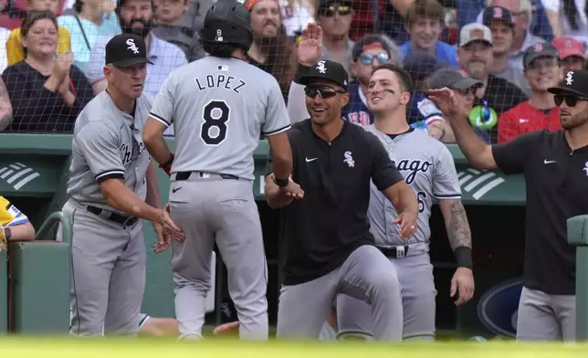 Chicago White Sox's Nicky Lopez (8) is welcomed to the dugout after scoring on a single by Jacob Amaya in the ninth inning of a baseball game against the Boston Red Sox, Sunday, Sept. 8, 2024, in Boston. (AP Photo/Steven Senne)