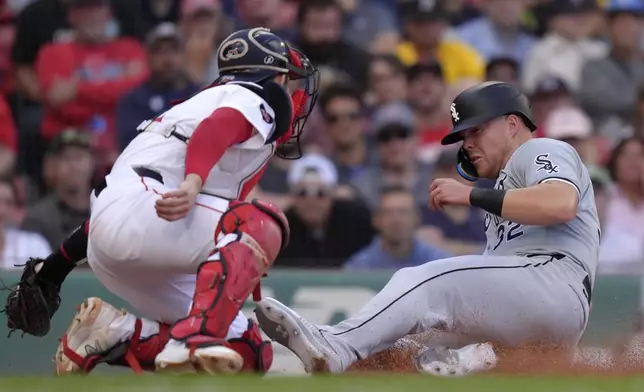 Chicago White Sox's Gavin Sheets, right, slides home to score as Boston Red Sox catcher Connor Wong, left, is unable to tag him in the ninth inning of a baseball game, Sunday, Sept. 8, 2024, in Boston. (AP Photo/Steven Senne)