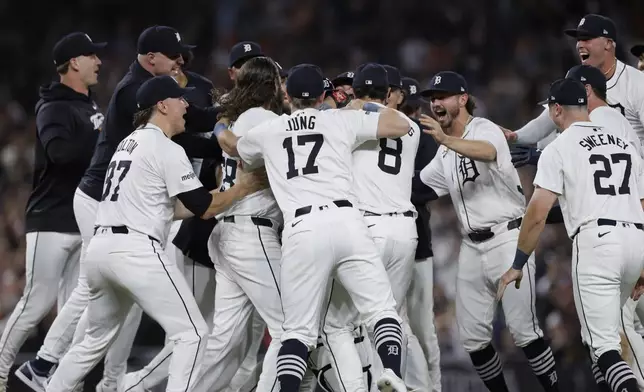 The Detroit Tigers, including Tyler Holton (87), Jace Jung (17), Matt Vierling (8), Zach McKinstry, Trey Sweeney (27) and Kerry Carpenter, celebrate after defeating the Chicago White Sox to win a wildcard spot in the major league baseball playoffs, Friday, Sept. 27, 2024, in Detroit. (AP Photo/Duane Burleson)