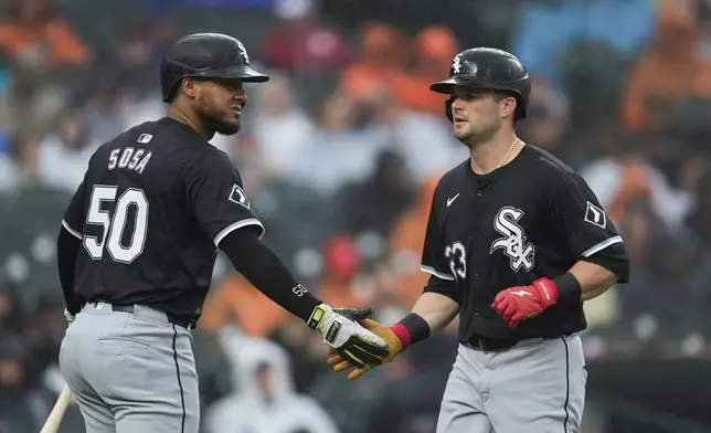 Chicago White Sox's Andrew Benintendi, right, celebrates scoring with Lenyn Sosa (50) against the Detroit Tigers in the sixth inning of a baseball game, Saturday, Sept. 28, 2024, in Detroit. (AP Photo/Paul Sancya)