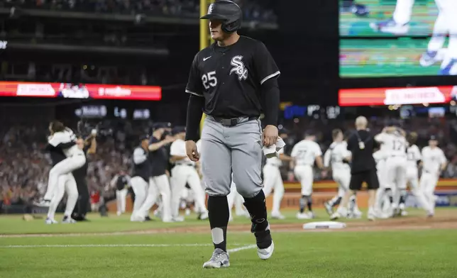 Chicago White Sox's Andrew Vaughn (25) walks off the field as the Detroit Tigers celebrate after making the playoffs after a win in a baseball game Friday, Sept. 27, 2024, in Detroit. (AP Photo/Duane Burleson)