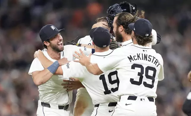 Members of the Detroit Tigers celebrate after the ninth inning of a baseball game against the Chicago White Sox, Friday, Sept. 27, 2024, in Detroit. (AP Photo/Carlos Osorio)